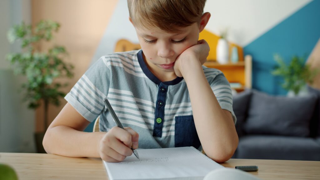 A young boy concentrating on homework at a desk