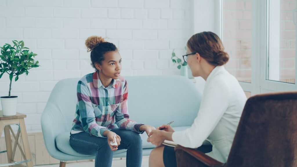 A therapist talking with a young woman during a therapy session